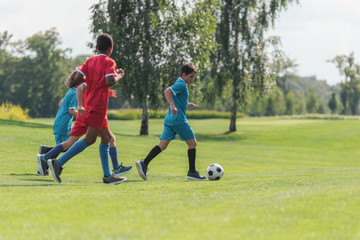 cropped view of kids playing football with african american friend