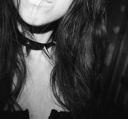 Black and white portrait of a beautiful gothic woman in black corset and spiked collar
