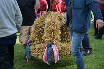 strong men carry the traditional harvest crown made from cereal stalks to the festive area for thanksgiving