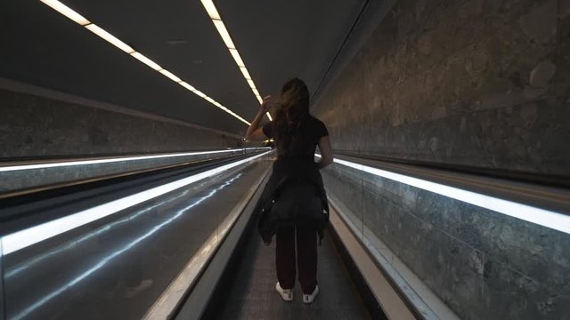 Woman standing on a walkalator - Barcelona, Spain
