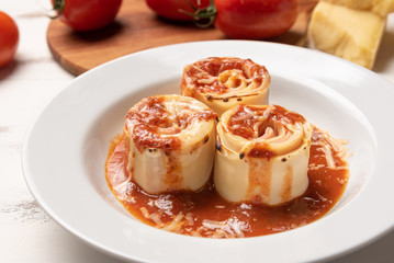 Traditional Italian Rondelli pasta with tomato sauce on rustic white wooden table background, soft light