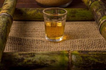 Cachaça is the name of a typical alcoholic drink produced in Brazil maked with sugarcane. Traditional drink from Brazil on wooden table