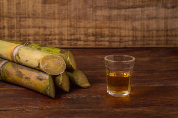 Cacha&ccedil;a is the name of a typical alcoholic drink produced in Brazil maked with sugarcane. Traditional drink from Brazil on wooden table