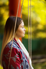Beautiful young woman on a swing portrait