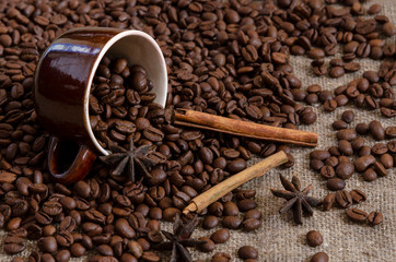 Coffee beans and badian on cup on the sackcloth background