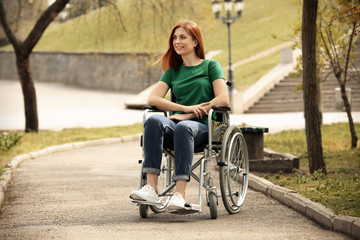 Fototapeta na wymiar Young woman in wheelchair at park on sunny day