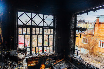 Burnt house interior. Burned kitchen, remains of furniture in black soot
