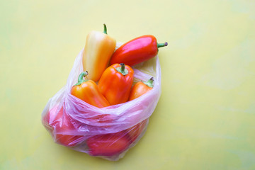 Recycling and environment concept: fresh food in plastic package. Bunch of wrapped bell peppers.