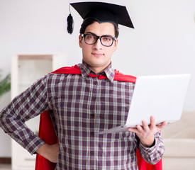Super hero student wearing mortarboard and holding a laptop