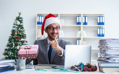 Young businessman celebrating christmas in the office