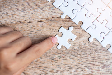 Businessman hand connecting  puzzle piece. Business solutions, mission target, successful, goals, cooperation, partnership and strategy concept