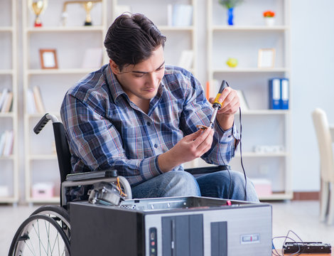 Computer repairman on wheelchair working