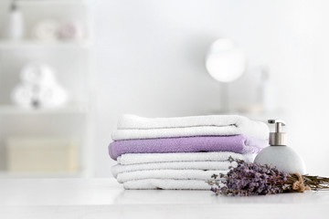 Soft clean towels with soap and lavender on table in bathroom
