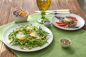 Plates with tasty salads on table