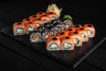 Sushi set with fresh ingredients on black background. Sushi menu. Japanese food. 