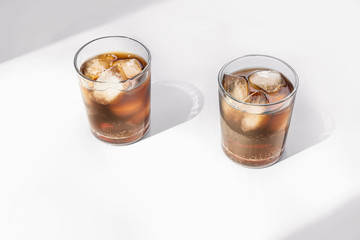 Glasses of cold cola on light background