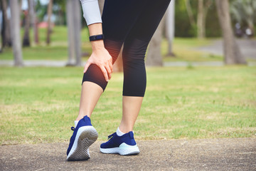 Woman runner hold her sports injured leg