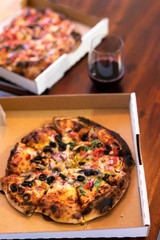 vegetarian woodfire pizza in cardboard box on wooden table setting
