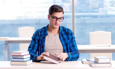 Student studying in the empty library with book preparing for ex