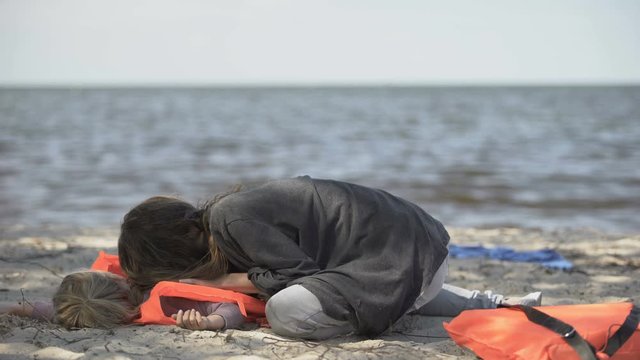 Mother trying to help unconscious daughter in life jacket, shipwreck victims