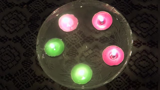 Close-up, high angle, colored tea lights floating in water, India
