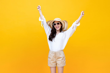 Happy smiling young Asian woman tourist raising hands up