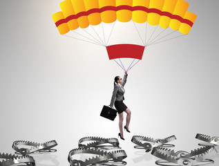 Businesswoman falling into trap on parachute