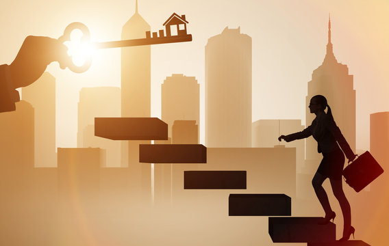 Businesswoman holding key in real estate concept