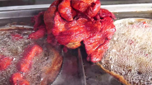 fried pork for tacos in oil in steel structure