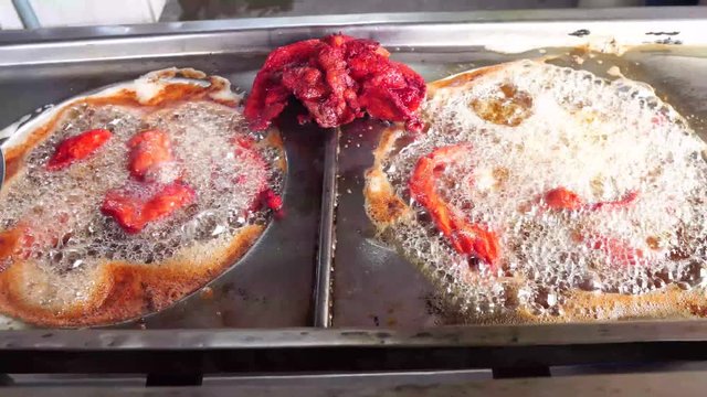 fried pork for tacos in oil in steel structure
