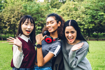 Group of smiling international students or teenagers standing and hugging together in park at university.Education and friendship Concept