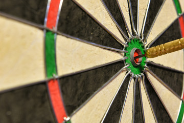 A dart hits the center of the darts board also known as "bulls eye" .