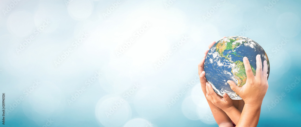 Sticker earth day concept: earth globe in family hands over blurred nature background. elements of this imag