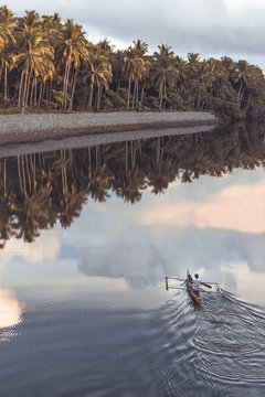 Southern Leyte, Philippines - July 14, 2019: Fishermen on a Fishing Boat with fishing net on a sunset in Southern Leyte Province, Philippines.