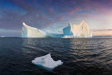 Iceberg at sunset. Nature and landscapes of Greenland. Disko bay. West Greenland. Summer Midnight Sun and icebergs. Big blue ice in icefjord. Affected by climate change and global warming. © Michal