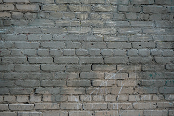 Texture of an old paint covered brick wall. Background image of an abandoned brick wall with painted over paint