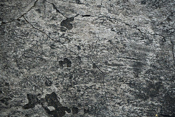 Texture of an old cracked concrete wall. Background image of a worn gray concrete surface