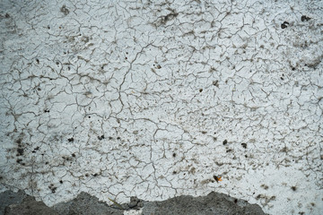 Texture of an old cracked concrete wall. Background image of a worn gray concrete surface