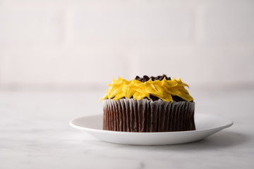 Beautiful sunflower decorated chocolate cupcake on marble table.