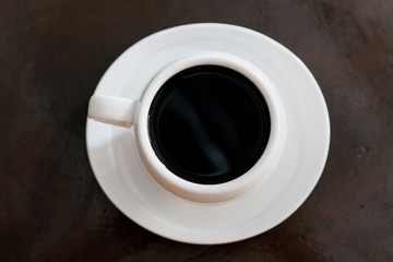 Tada with coffee, white color in small plate on the table.
