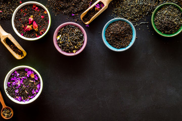 Dry leaves of herbal tea frame on black background top view mock-up