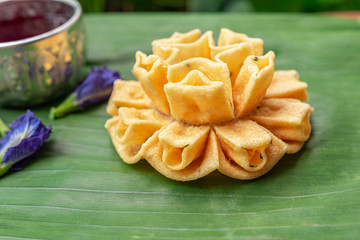 Crispy lotus blossom cookies on a green leaf. Thai traditional snack. Thai homemade cookies.