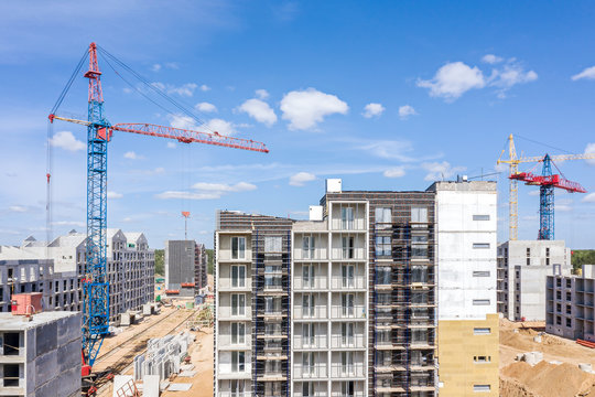 tower cranes and modern apartment building under construction. aerial view