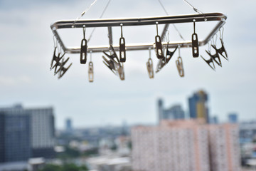 Naklejka premium Clothespin hanging on a skyscraper background.