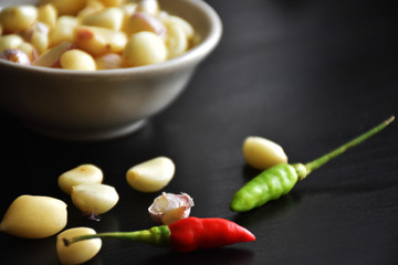 bowl of vegetable ,garlic,chilies on black table.