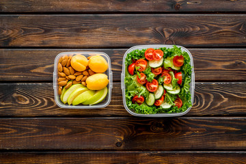 Food container with healthy food on wooden background top view