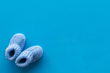 Booties for newborn girl on blue background top view mock up