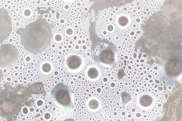 Circle water drops macro from under the plastic material.