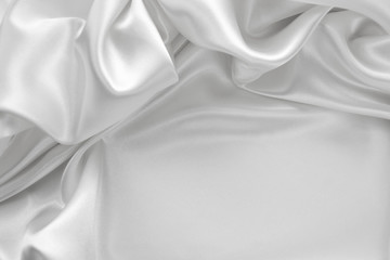 Fototapeta na wymiar Delicate satin draped fabric white texture for festive backgrounds