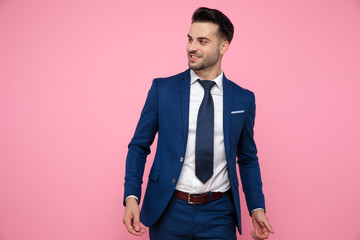 attractive young man walking on pink background